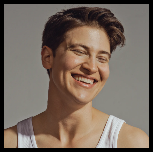 A headshot of the author smiling with eyes closed and a full head of short hair, top of a white undershirt visible.